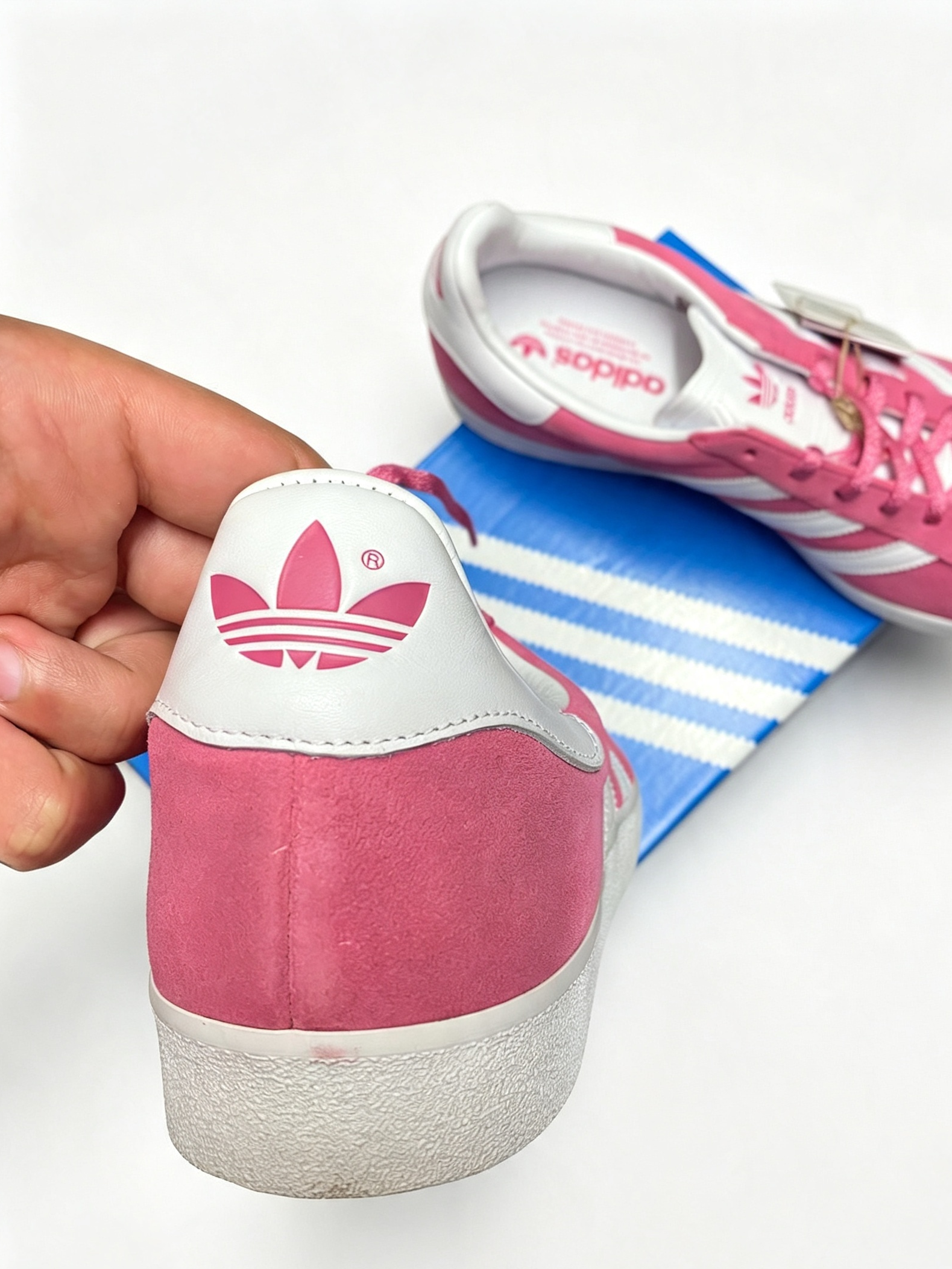 Pink Adidas Gazelle 85's Girls Sneakers Shoes with another shoe resting on a blue and white striped Adidas box in the background.