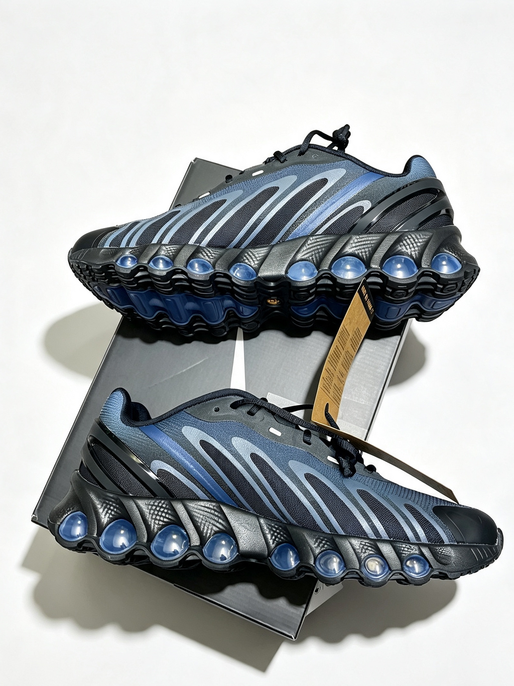 A pair of Nike Air Max 2013 sneakers in a dark blue and black colorway, displayed on a black presentation box against a white background.